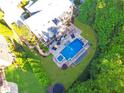 Aerial view of the home and backyard which features a pool, spa, and outdoor seating on a stone patio at 2325 Manor Creek Ct, Cumming, GA 30041