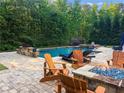 Backyard with pool, spa, and firepit, and wood adirondack chairs on a paved patio at 2325 Manor Creek Ct, Cumming, GA 30041