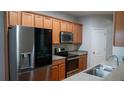 Well-lit kitchen featuring stainless steel appliances, granite countertops, and light wood cabinetry at 2476 Suwanee Pointe Dr, Lawrenceville, GA 30043