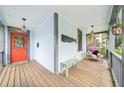 Inviting front porch featuring a cozy seating area, an orange front door, and nautical accents at 621 Mcgruder Ne St, Atlanta, GA 30312