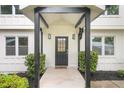 Covered porch with black support columns, transom window, and manicured landscaping at 146 Mount Paran Ne Rd, Atlanta, GA 30342