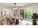 Elegant dining room with hardwood floors, wainscoting, modern light fixture, and a walk-out to a balcony at 201 E Simon Nw Ter, Atlanta, GA 30318
