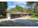 View of a brick home featuring a two-car garage and long driveway at 201 E Simon Nw Ter, Atlanta, GA 30318