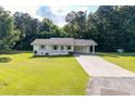 Charming one-story home with white exterior, a carport, manicured lawn, and lovely landscaping at 10 Casey Ln, Cartersville, GA 30121