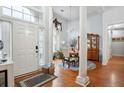 Inviting entryway with hardwood floors, columns, and an elegant chandelier above a dining table at 132 Eagles Club Dr, Stockbridge, GA 30281