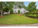 Charming white home featuring a well-manicured lawn and beautifully landscaped front yard at 132 Eagles Club Dr, Stockbridge, GA 30281