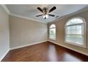 The bedroom features hardwood floors, a ceiling fan, and arched windows, offering ample natural light at 2312 Mahogany Glen Pl, Lawrenceville, GA 30043
