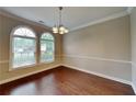 Inviting dining room with hardwood floors, elegant chandelier, and natural light from the arched windows at 2312 Mahogany Glen Pl, Lawrenceville, GA 30043