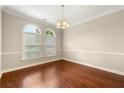 Dining room with rich hardwood flooring and classic chandelier fixture with chair railing at 2312 Mahogany Glen Pl, Lawrenceville, GA 30043
