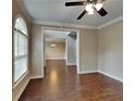 Open-concept living area with hardwood floors, crown molding, and view into dining and living spaces at 2312 Mahogany Glen Pl, Lawrenceville, GA 30043