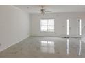 Bright and airy living room showcasing light marble flooring and ample natural light from a large window at 5090 Leeshire Trce, Tucker, GA 30084