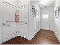 Bright hallway with hardwood floors, white doors, and modern wall decor at 6315 Princeton Ridge Dr, Lithonia, GA 30058