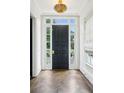 Welcoming foyer with dark wood herringbone floors, a black front door, and a decorative gold light fixture at 444 Rock Springs Ne Rd, Atlanta, GA 30324