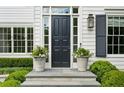 Elegant front entry with classic black door, flanked by potted flowers and sidelights, atop stone steps at 444 Rock Springs Ne Rd, Atlanta, GA 30324