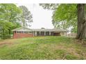 Low angle view of the ranch-style home showing the front yard with mature trees at 4935 Golden Sw Cir, Mableton, GA 30126