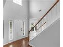 Bright foyer with hardwood floors features a staircase and a view of the front door at 973 Buckhorn Bnd, Locust Grove, GA 30248