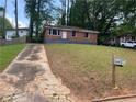 Charming home with a brick exterior and a cracked driveway leading up to the house at 2545 Saint Patrick Se St, Atlanta, GA 30317