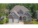Attractive exterior featuring stone accents, a covered porch, and a spacious two-car garage at 5755 Vinings Place Se Ct, Mableton, GA 30126