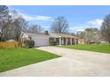 A ranch-style home with an extra-long driveway and manicured lawn on a sunny day at 897 Marie Sw Ln, Conyers, GA 30094