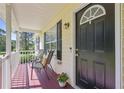 Inviting front porch with seating, a black front door, and a view of the surrounding greenery at 213 Johnstons Dr, Dallas, GA 30157