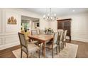Formal dining room with paneled walls, hardwood floors, chandelier, and stylish furnishings at 1018 Layfield Ct, Dunwoody, GA 30338