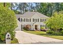 Charming two-story home with a well-kept lawn, mature trees, and a classic white facade at 1018 Layfield Ct, Dunwoody, GA 30338