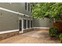 Exterior view of backyard patio with stone pavers, gravel, wooden fence, and string lights overhead at 1202 Hardee Ne St, Atlanta, GA 30307