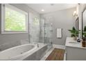 Modern bathroom with a soaking tub, frameless glass shower, double vanity, and a large window at 1202 Hardee Ne St, Atlanta, GA 30307