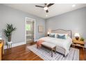 Well-lit bedroom features a queen bed, decorative rug and bench, and an ensuite bathroom at 1202 Hardee Ne St, Atlanta, GA 30307