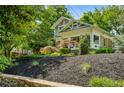 Landscaped front yard featuring a stone wall, mulch beds, and mature trees surrounding a two-story home at 608 Sherwood Ne Rd, Atlanta, GA 30324
