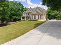 Wide driveway leading to a well-maintained two-story house with a neatly landscaped front yard at 4525 E Point Dr, Cumming, GA 30041