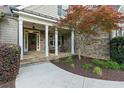 Inviting front porch with stone accents, columns, and a cozy seating area at 1686 Brooks Farm Nw Dr, Acworth, GA 30101