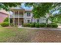 Two-story home with covered porch and stone accents, surrounded by mature trees and well-maintained landscaping at 944 Hidden Falls Se Ln, Smyrna, GA 30082