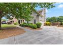 Side exterior view of home, showcasing the attached garage and driveway with manicured landscaping at 944 Hidden Falls Se Ln, Smyrna, GA 30082