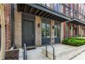 Modern townhome entrance featuring a brick facade, a steel awning, and a poured concrete pathway at 1225 Chelsea Nw Cir, Atlanta, GA 30318