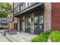 Modern townhome entrance featuring a brick facade, a steel awning, and professionally landscaped bushes at 1225 Chelsea Nw Cir, Atlanta, GA 30318