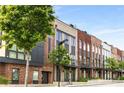 Modern townhomes featuring brick exteriors, black trim, balconies and professionally landscaped front yards at 1225 Chelsea Nw Cir, Atlanta, GA 30318