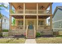 Beautiful home exterior with a double porch, ceiling fans, brick foundation, and a well-maintained front yard at 1858 Perry Nw Blvd, Atlanta, GA 30318