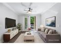 Bright living room with hardwood floors, sofa, and entertainment center; leads to an outdoor balcony at 901 Abernathy Ne Rd # 2050, Sandy Springs, GA 30328