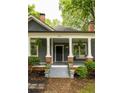 Charming front porch with columns, brick accents, stairs and beautifully landscaped flower beds at 230 Milton Se Ave, Atlanta, GA 30315