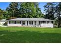 Beautifully renovated home with black shutters, white paint, and a well-maintained lawn at 2604 Flat Shoals Sw Rd, Conyers, GA 30094