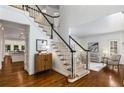 Inviting foyer with hardwood floors, a staircase with white spindles, and views into the living spaces at 4679 Glenshire Pl, Atlanta, GA 30338