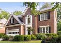 Beautiful brick house featuring manicured landscaping, an arched window, and a two-car garage at 4679 Glenshire Pl, Atlanta, GA 30338