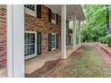 Detailed shot of brick facade with black shutters, showing the home's front door and side yard at 3539 Evans Mill Rd, Lithonia, GA 30038