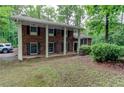 Traditional brick home with white columns, shutters, and a well-manicured lawn and tree-lined landscape at 3539 Evans Mill Rd, Lithonia, GA 30038