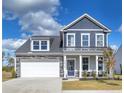 Two story home with gray siding, stone accents, a covered porch with rocking chairs, and an attached two car garage at 508 Regency Trl, Acworth, GA 30102