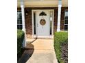 Inviting front door framed by brick accents and manicured hedges at 5458 Stagecoach Rd, Ellenwood, GA 30294
