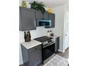Well-equipped kitchen featuring modern appliances and stylish gray cabinetry at 5458 Stagecoach Rd, Ellenwood, GA 30294
