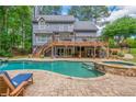Stunning backyard showcasing a sparkling pool, spa, and an expansive wooden deck at 1100 Lady Slipper Way, Canton, GA 30115