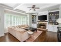 Inviting living room featuring custom built-ins, a fireplace, and hardwood floors at 1100 Lady Slipper Way, Canton, GA 30115